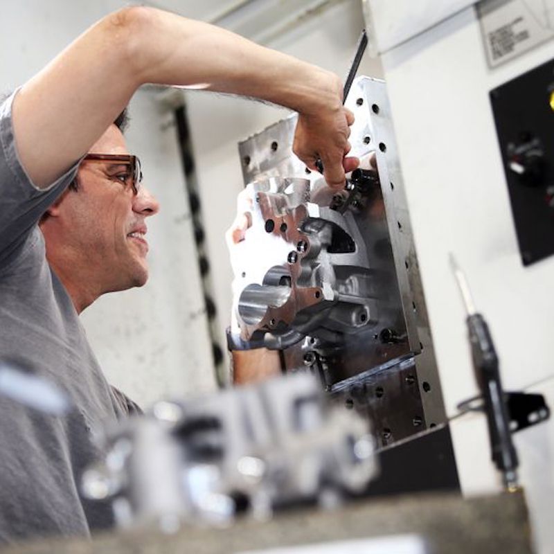 A man using a wrench to fix a machine.