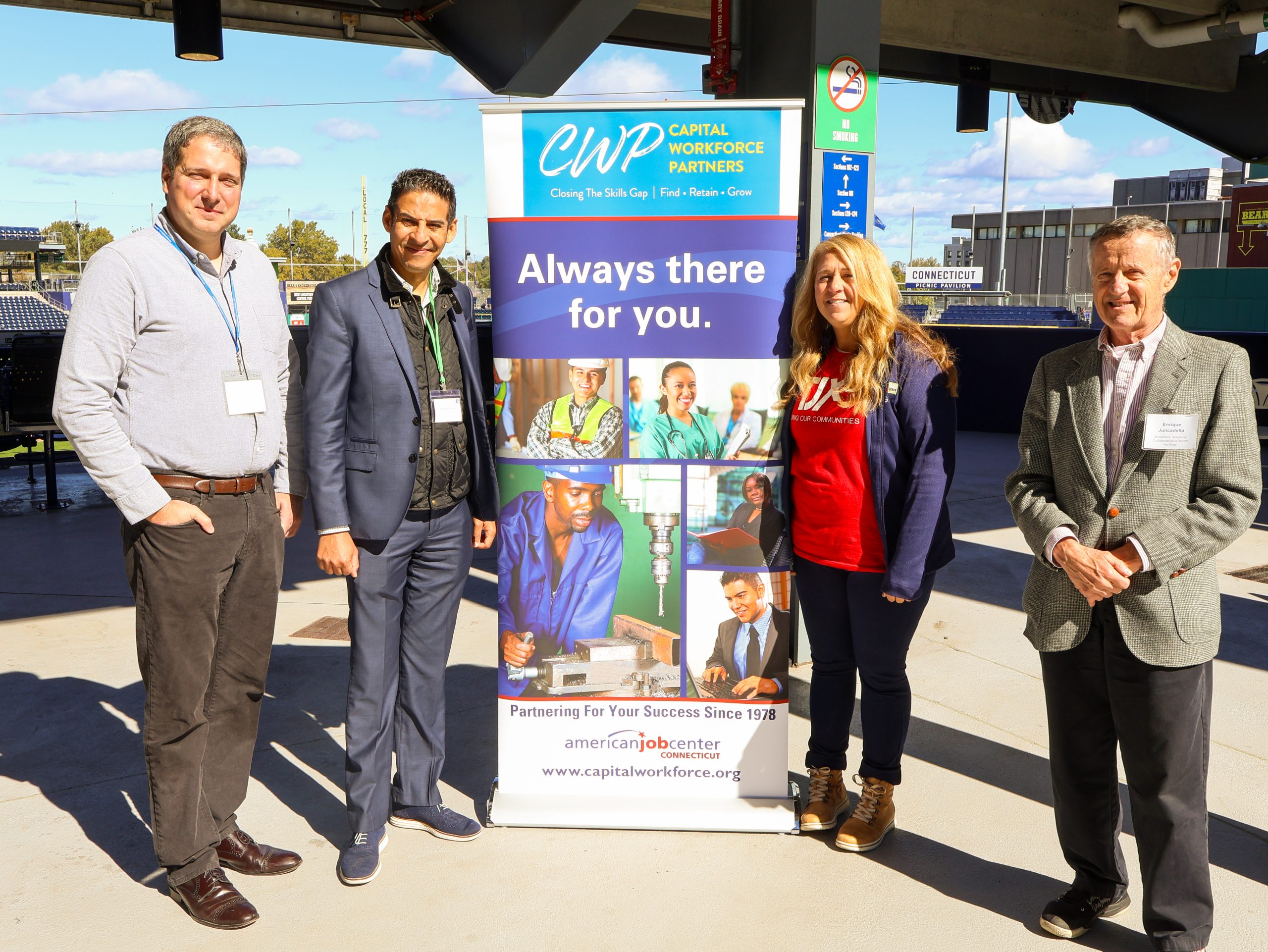 Business Services Representatives at a jobfair at a baseball stadium in front of a Capital Workforce Partners Banner that says "Always there for you."