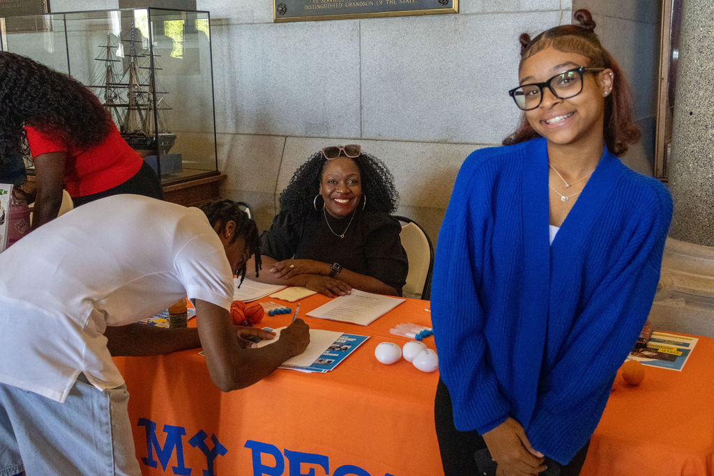 SYELP Intern in front of a table at the end of the Summer Internship