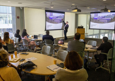 Man presenting at a projector screen in front of group of people