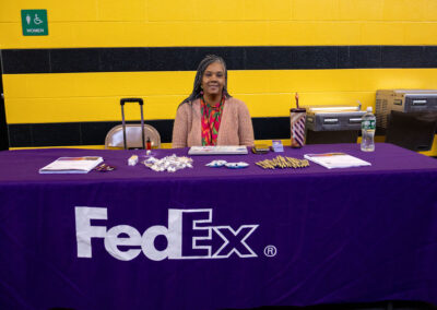 Woman sitting behind a table at job fair.