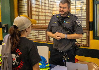 Young adult job seeker speaking with a police officer at TDL Hiring Event